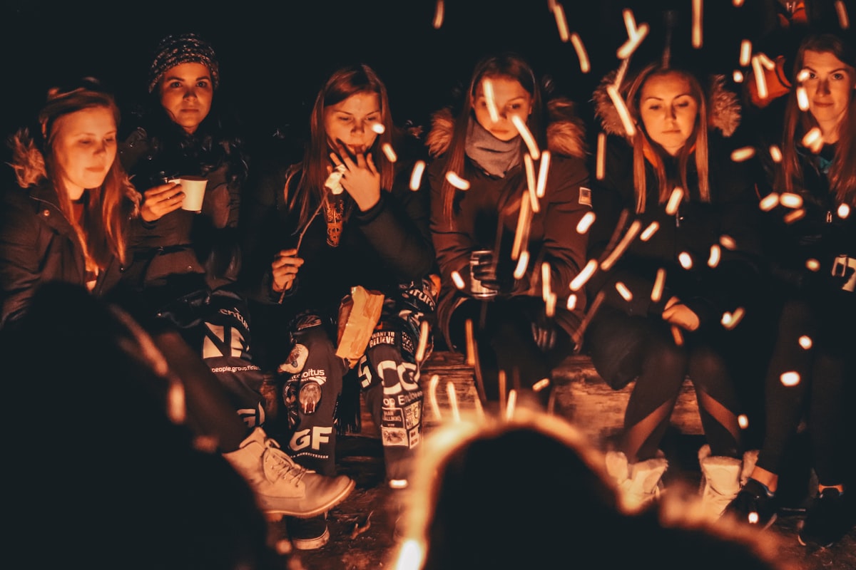 People gathered close around a bonfire at night
