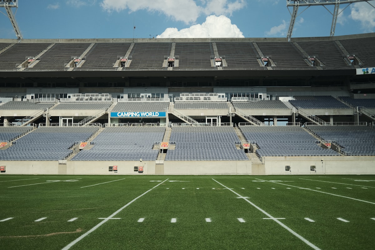 A wide-angle view of an empty American football stadium under a partly cloudy sky