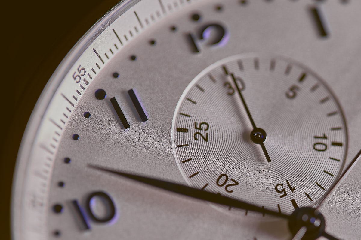 An analog hourglass with sand falling, soft natural light, quiet room