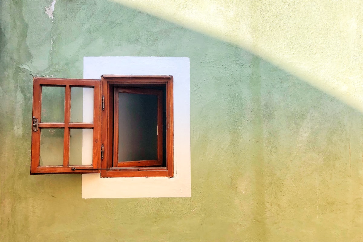 An open wooden window letting in early morning light