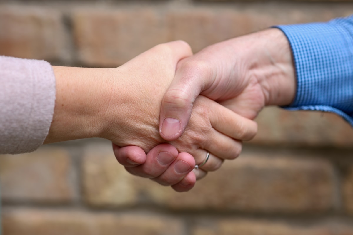 Close-up of two people's hands shaking, meeting for the first time