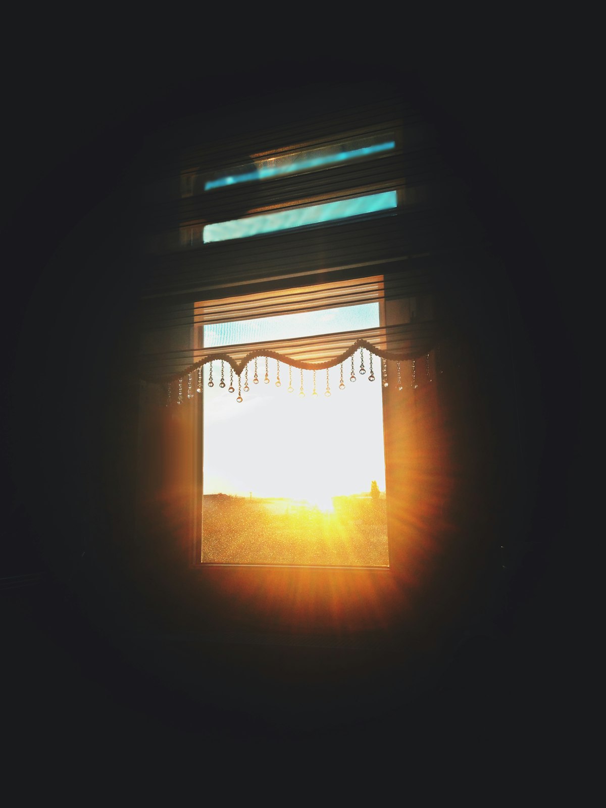 Bright sunlight breaking through a window into a darkened room