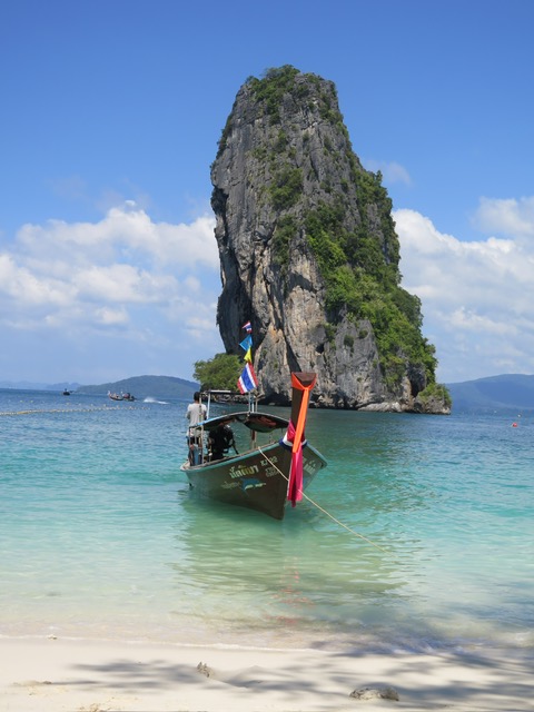 Longtail boat anchored beneath Railay's limestone cliffs